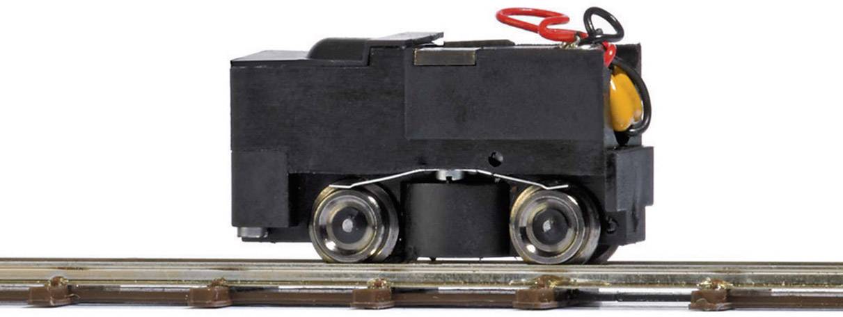 Un petit modèle d'un véhicule ferroviaire noir avec des roues sur un rail. Il comporte des câbles colorés et des détails en surface.
