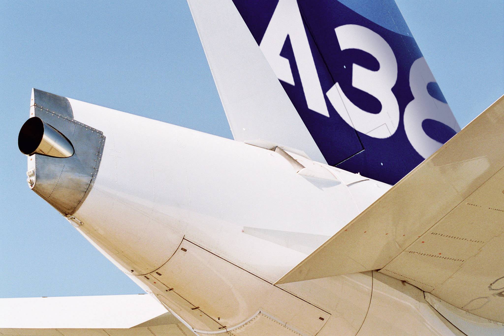 Arrière d'un avion avec empennage et tuyère de réacteur visibles contre un ciel bleu. Le numéro 'A380' est lisible sur l'empennage.