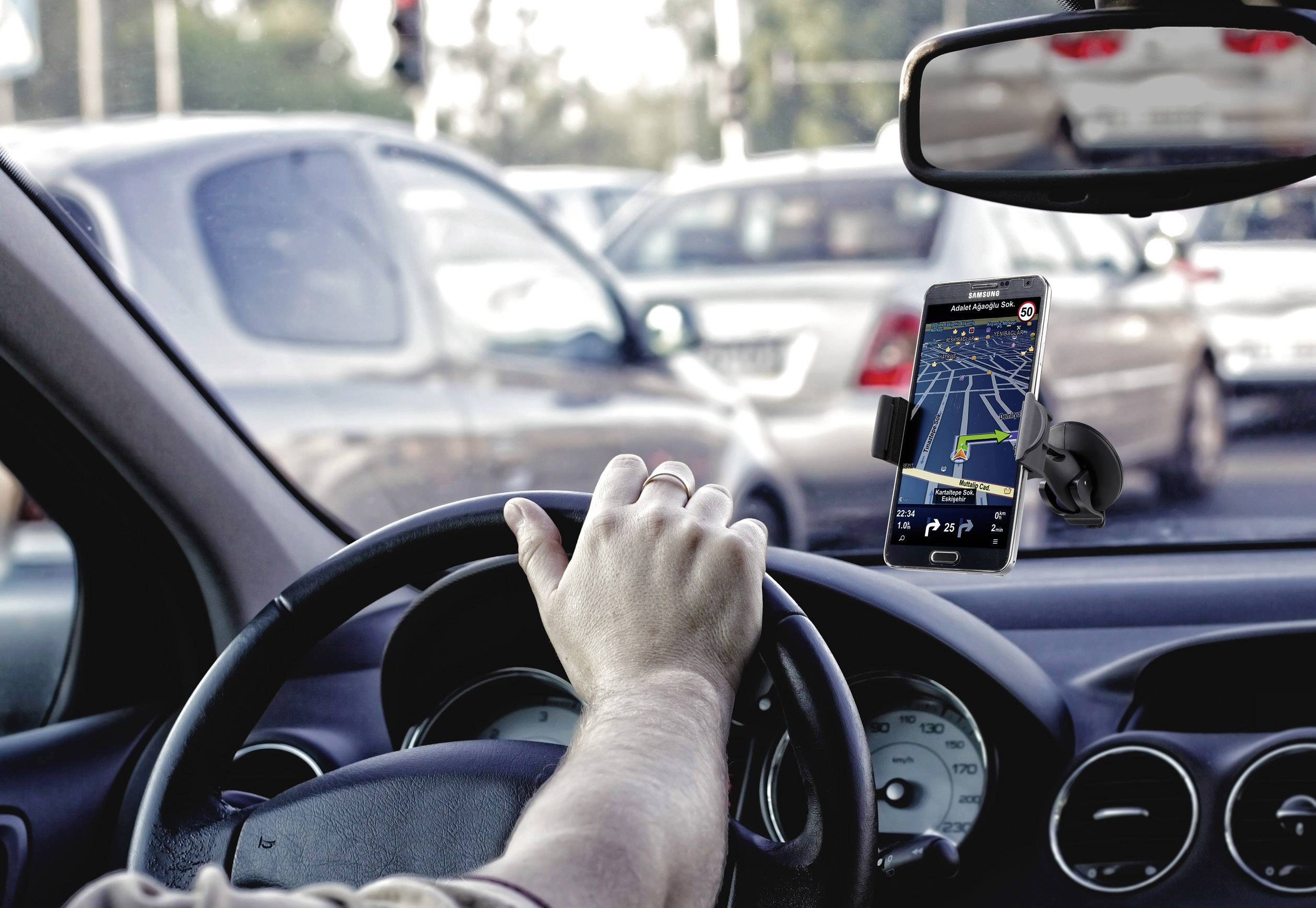 Un automobiliste navigue à travers un trafic dense à l'aide d'un smartphone fixé sur un support et servant de GPS.