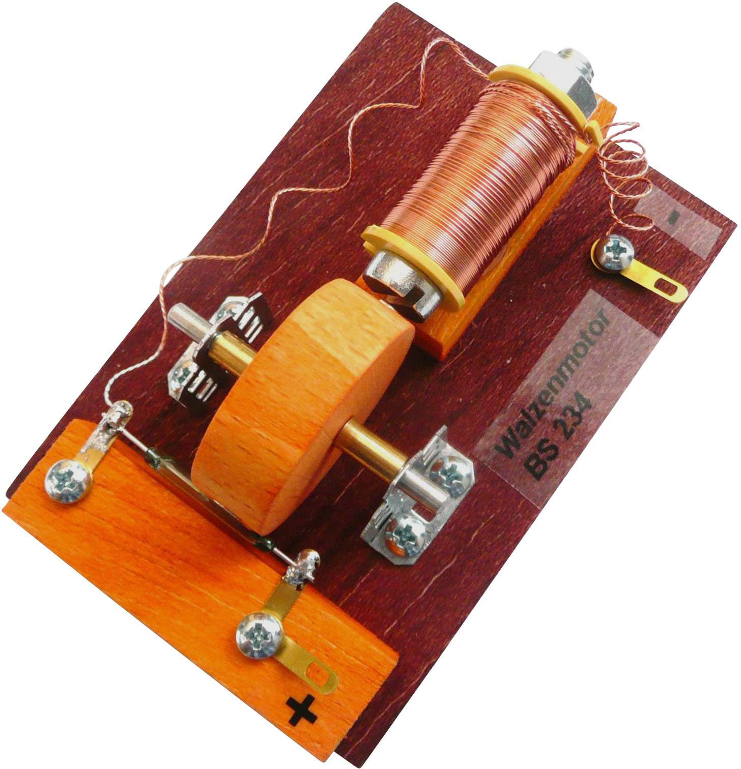 Un moteur électrique simple sur une plateforme en bois montre une bobine, des aimants et un point de contact. Étiquette 'Watzenmotor BS 234'.