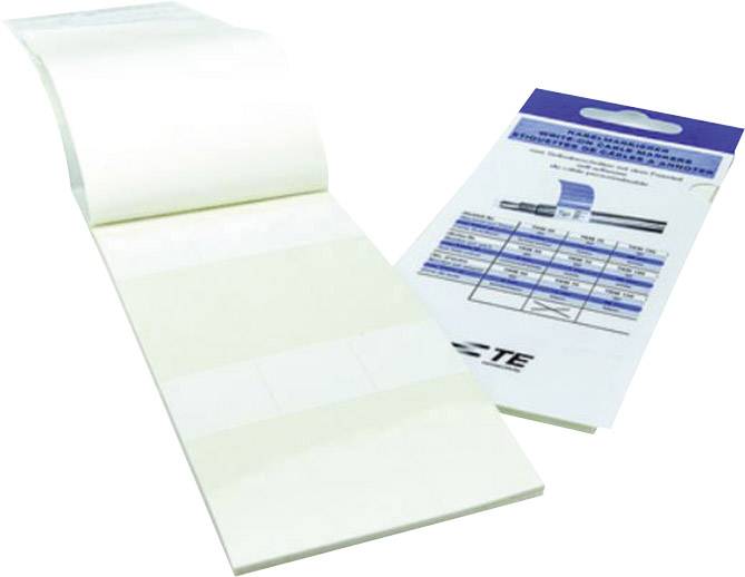 Bloc-notes avec des étiquettes blanches, à côté d'un emballage avec un tableau et une inscription bleue.