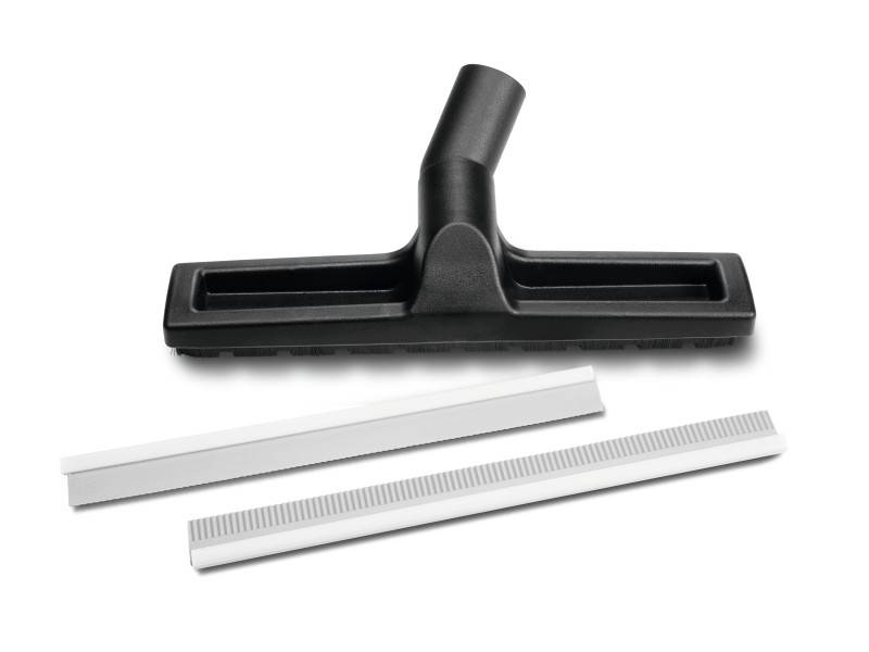 Un embout d'aspirateur noir est posé à côté de deux baguettes en plastique blanc et allongées sur un fond neutre.