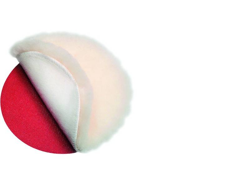 Un coussin douillet et rond avec un fond rouge, probablement fait d'un matériau pelucheux, légèrement incliné.