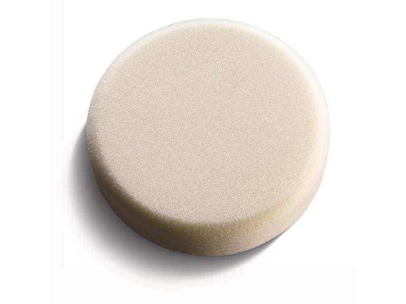 Éponge ronde de couleur beige en mousse, sur un fond blanc.