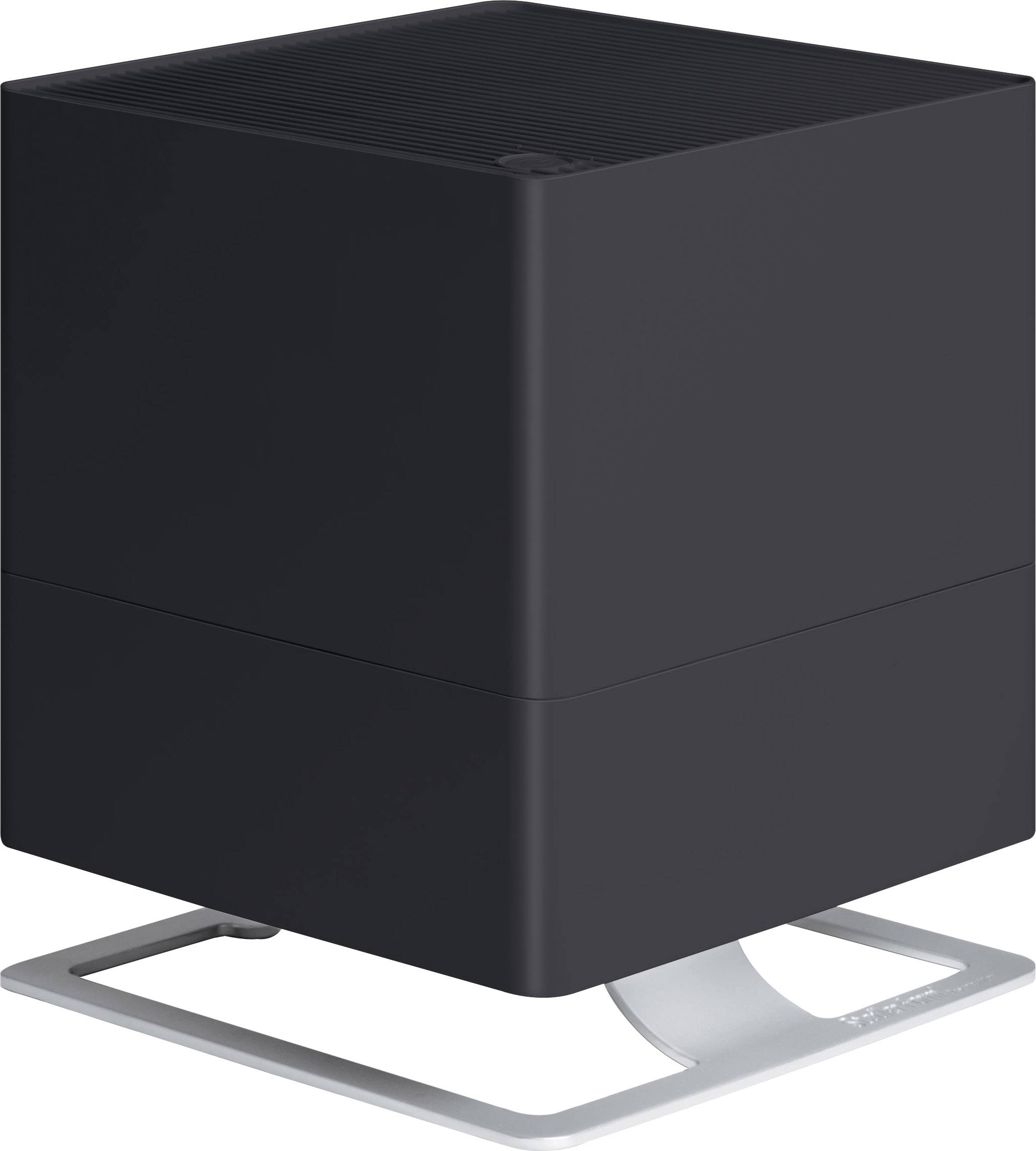 Un purificateur d'air moderne noir en forme de cube, posé sur un support métallique aux lignes courbes. Adapté pour une utilisation en intérieur.