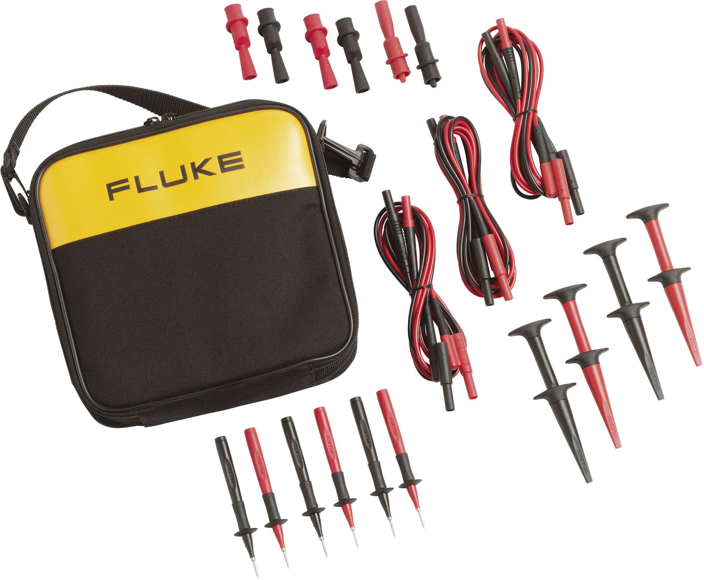 Un sac jaune et noir portant l'inscription 'FLUKE', entouré de différentes sondes de test et de câbles en rouge et noir.