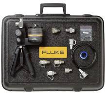 Valise à outils avec logo 'Fluke', contenant un appareil de mesure, divers adaptateurs et câbles. Convient pour les mesures techniques et l'étalonnage.