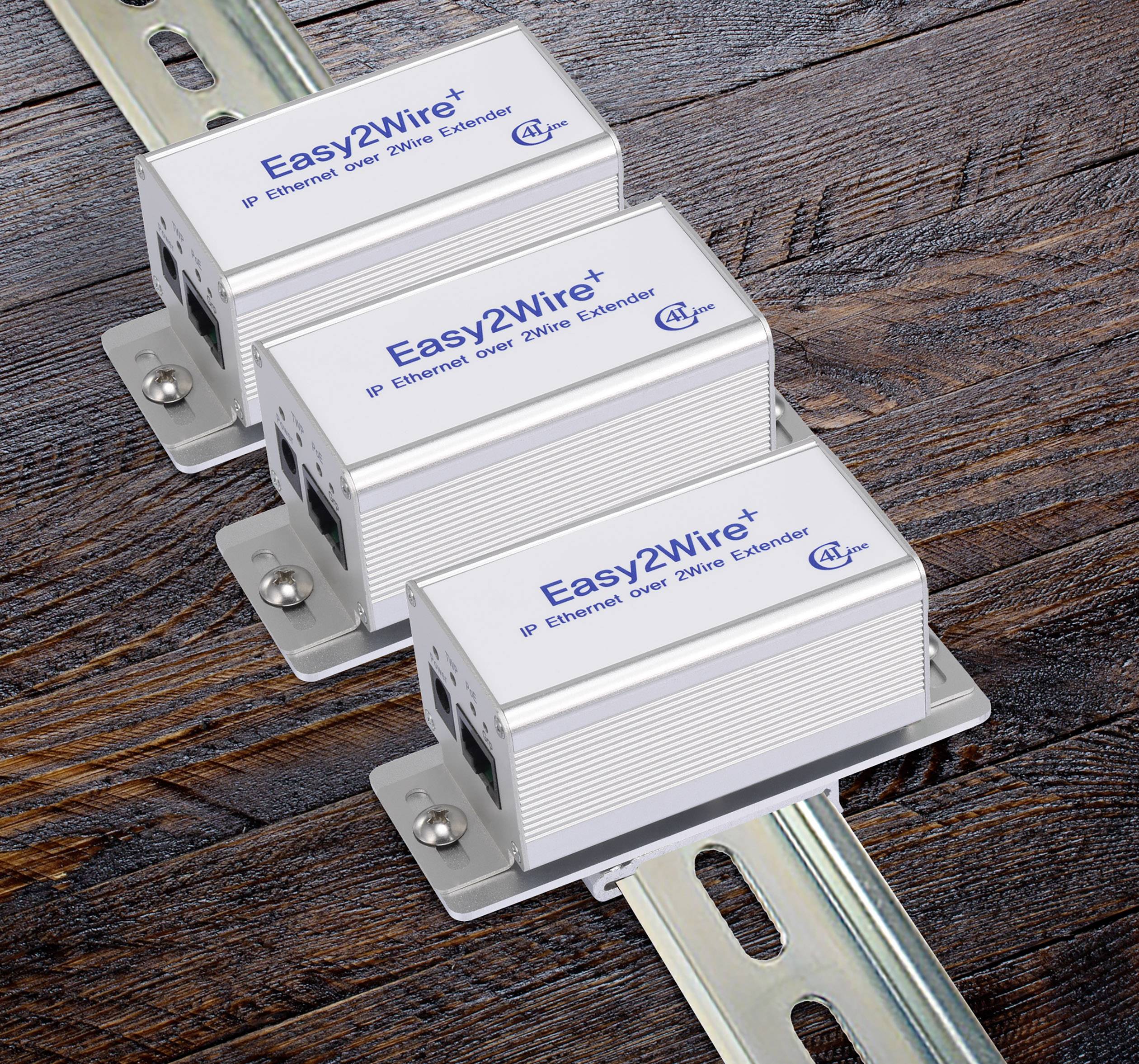 Trois prolongateurs IP Ethernet 'Easy2Wire+' sur surface en bois, montrant le logo et la fonction d'extension Ethernet sur ligne à deux fils.