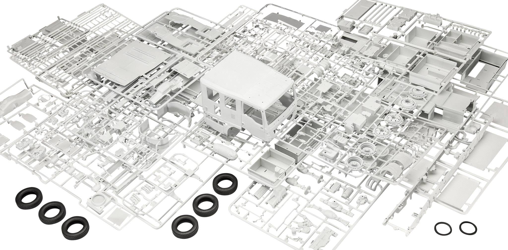 Pièces d'un kit de modélisme automobile en plastique, étalées sur une surface. Comprend la carrosserie, les roues et divers composants.