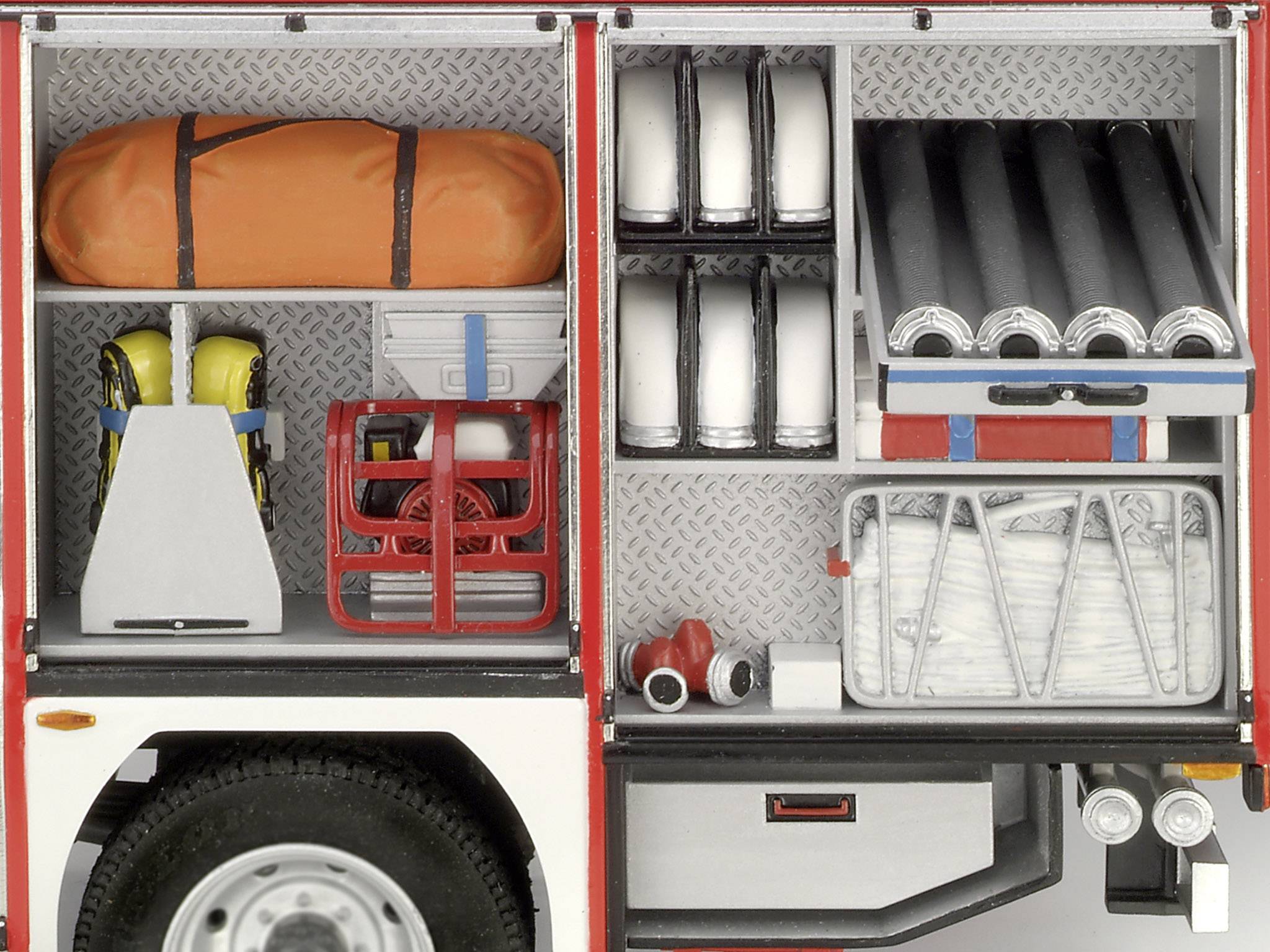 Une voiture de pompiers aux compartiments ouverts montre de l'équipement tel que des masques respiratoires, des tuyaux, un ventilateur, un casque et une bonbonne jaune.