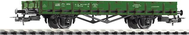 Un wagon de marchandises vert sur des rails. Le wagon présente différents détails techniques et inscriptions sur son côté.