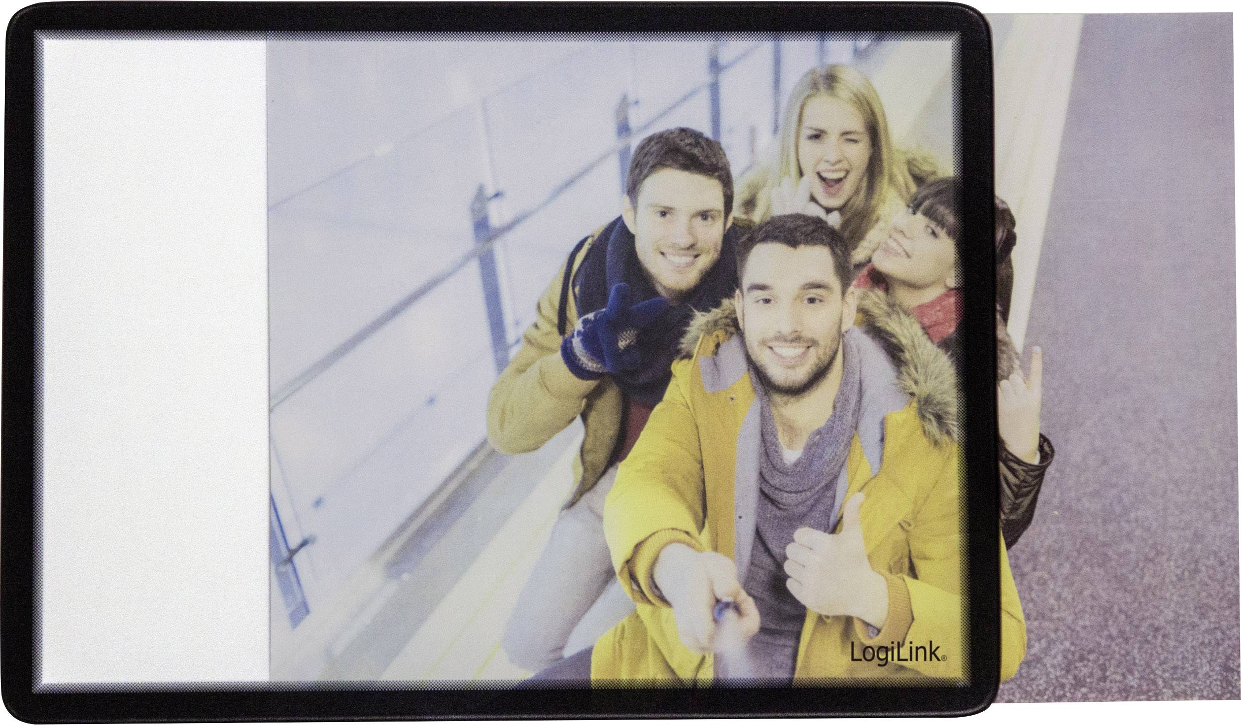 Un groupe de quatre personnes souriantes prend un selfie avec une perche à selfie. Ils portent des vêtements chauds et se trouvent à l'intérieur.
