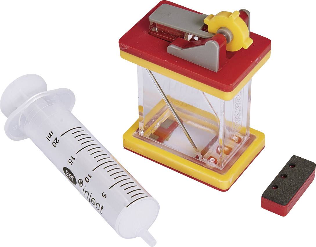 Une seringue et un coffret d'expérimentation physique en plastique rouge et jaune, adapté pour des expériences scientifiques.