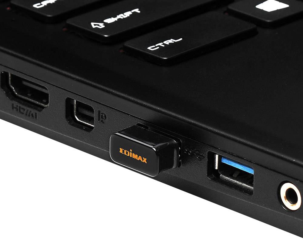 Un ordinateur portable avec une clé USB Edimax branchée et des ports HDMI et USB visibles. Étiquettes de touches en haut : « MAJ », « CTRL ».