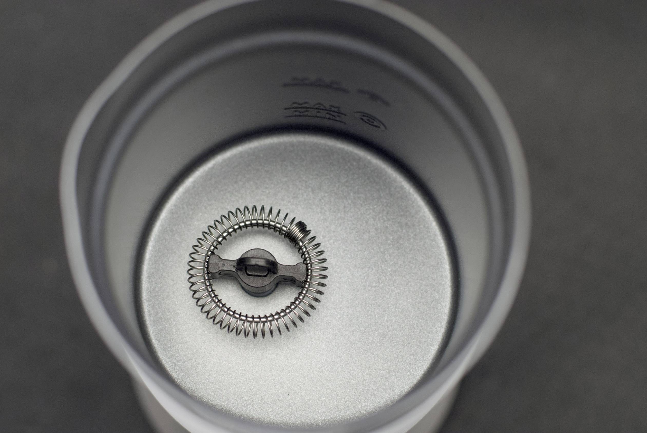 Un engrenage métallique se trouve dans une structure cylindrique en métal gris. L'environnement semble industriel et mécanique.