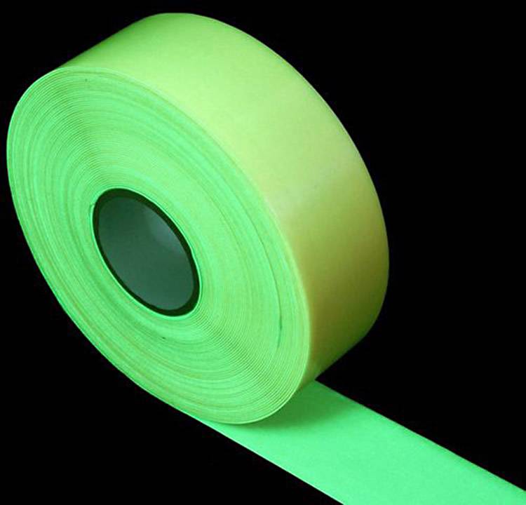 Un rouleau de ruban adhésif vert fluorescent sur un fond noir.
