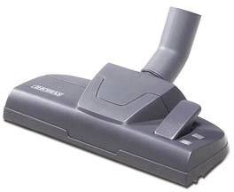 Buse d'aspirateur grise sur fond blanc. Adaptée au nettoyage des tapis ou des surfaces dures, de forme rectangulaire avec un raccordement pivotant.