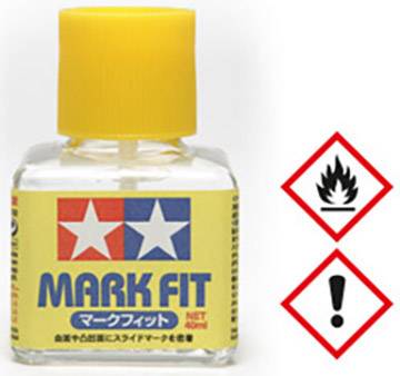 Bouteille avec un bouchon jaune portant l'inscription 'MARK FIT'. Deux pictogrammes de danger à côté : flamme et point d'exclamation.