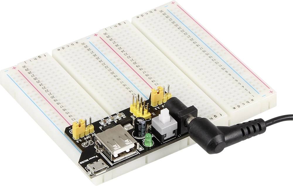 Carte de prototypage avec bloc d'alimentation connecté, plusieurs broches de connexion et un port USB, prête pour des projets de circuits électroniques.
