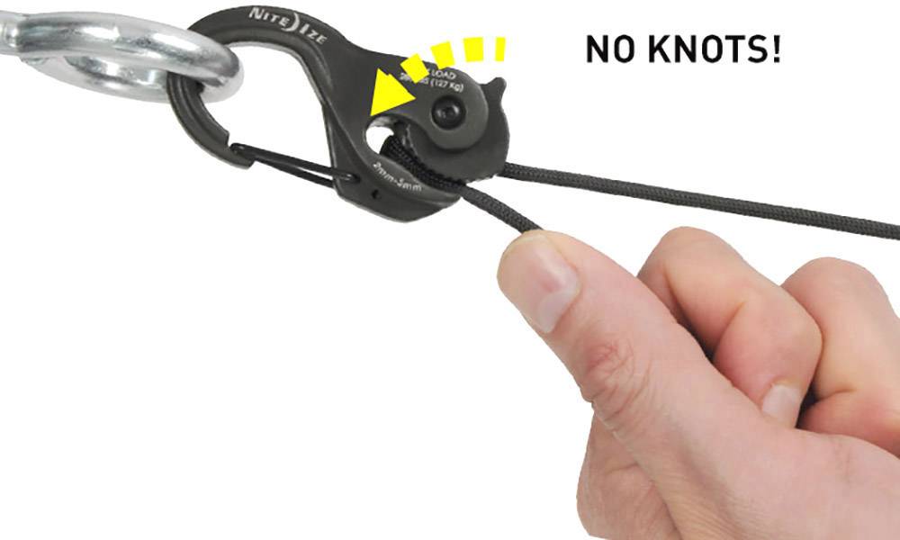 Une main tire sur une corde passant à travers un clip noir portant l'inscription « PAS DE NŒUDS ! » afin d'établir une connexion solide.
