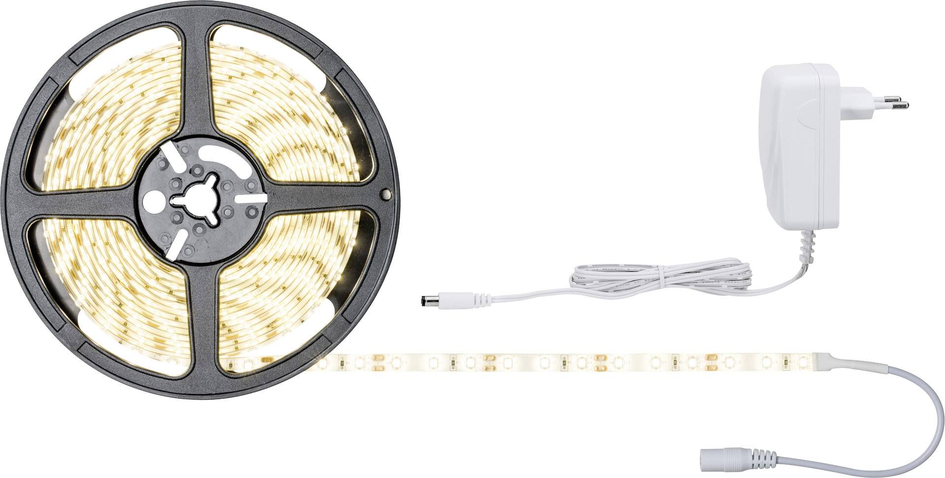Une bande lumineuse LED sur un rouleau, équipée d'un bloc d'alimentation et d'un câble. La bande est partiellement déroulée et montre des LED de couleur blanc chaud.