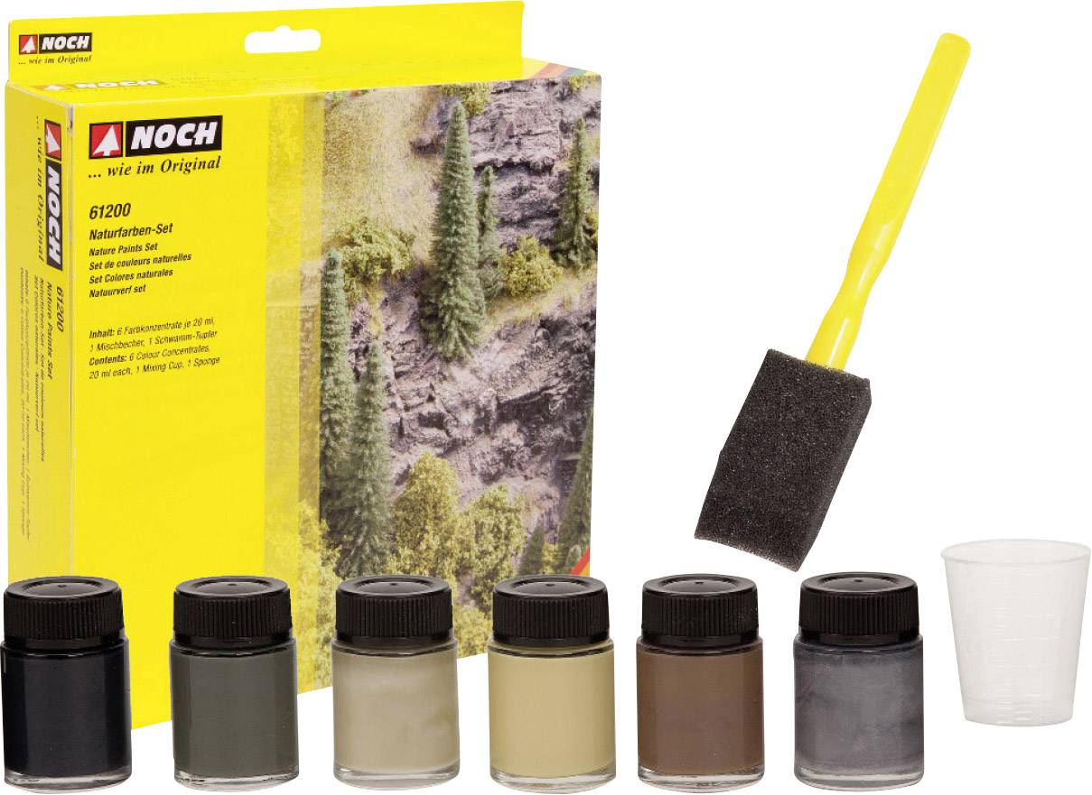 Six pots de peinture dans des tons de terre, un pinceau-éponge et un petit gobelet doseur à côté d'un emballage représentant un paysage.