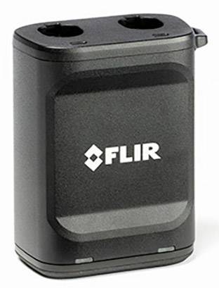 Un appareil noir et rectangulaire portant le logo 'FLIR' au centre. Il comporte deux ouvertures en haut et est environ de la taille d'une main.