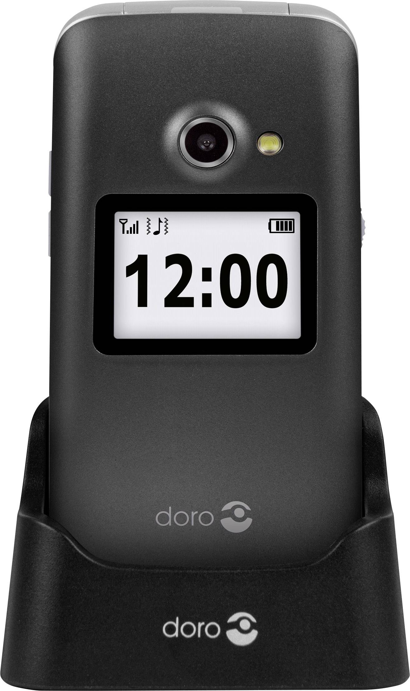 Téléphone portable à clapet posé dans son socle de chargement, affichant l'heure '12:00' sur l'écran externe.