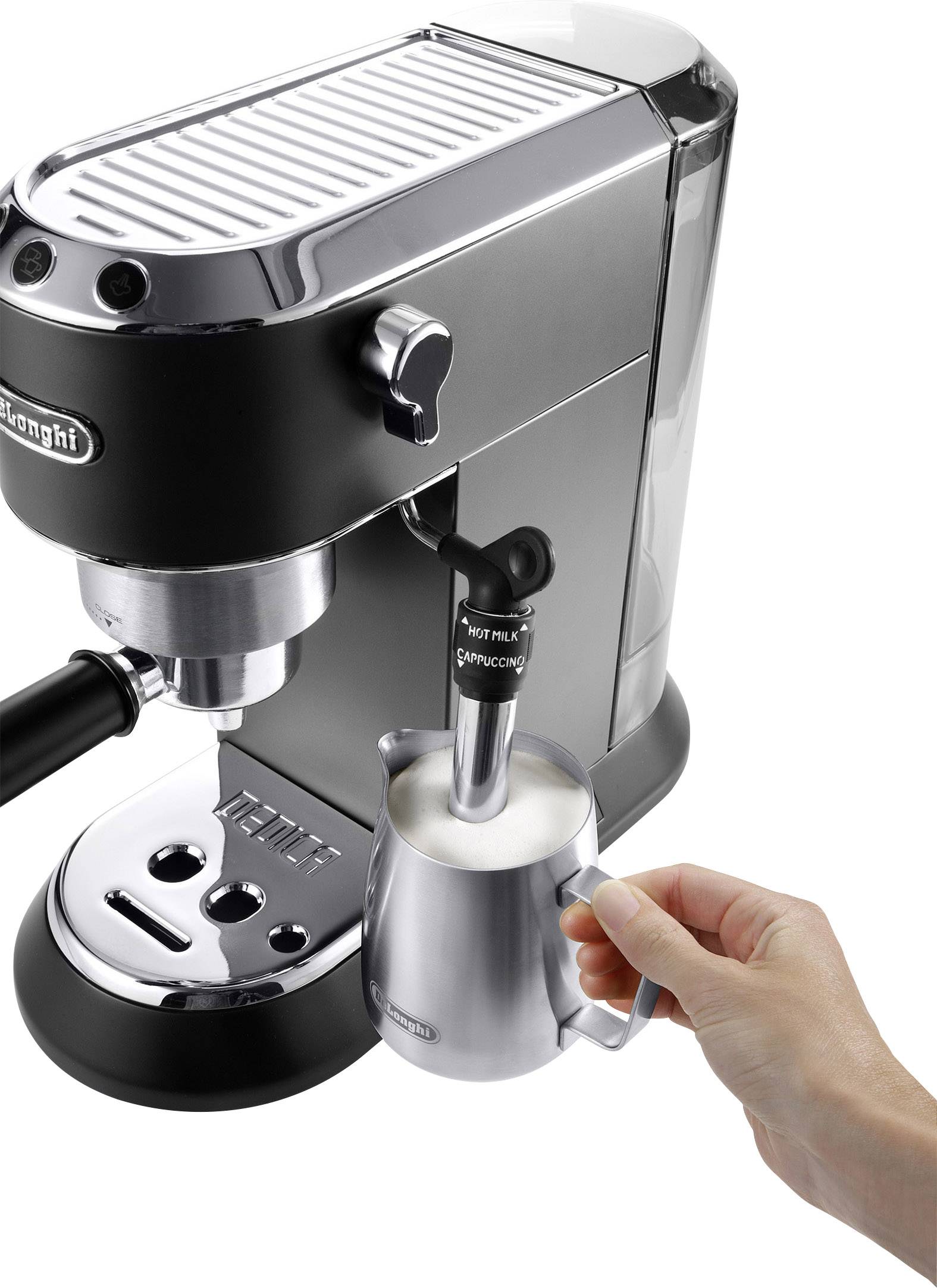 Une main fait mousser du lait avec une machine à café argentée.