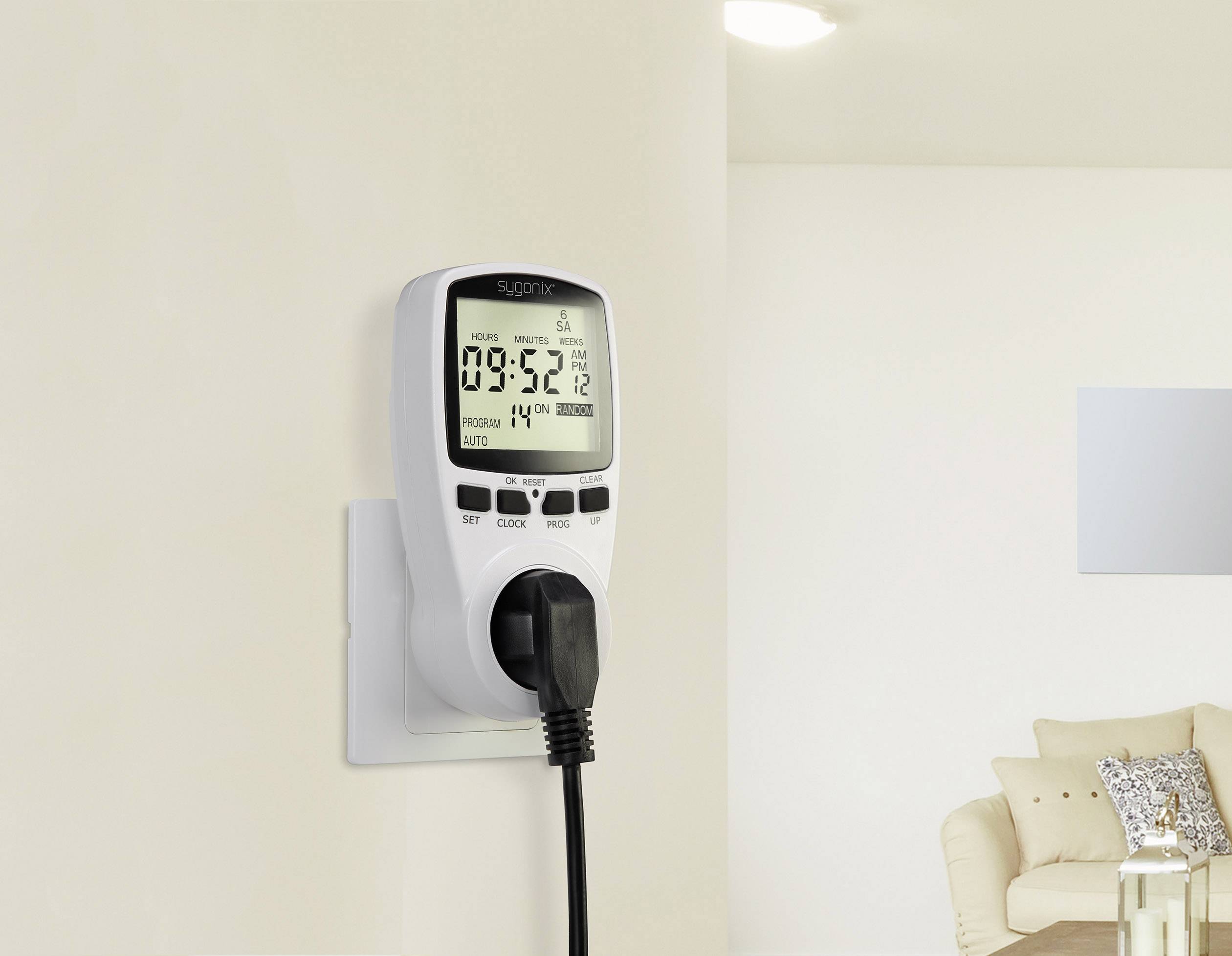 Un interrupteur horaire numérique est branché à une prise électrique, affiche l'heure 09:52 et contrôle un appareil connecté.