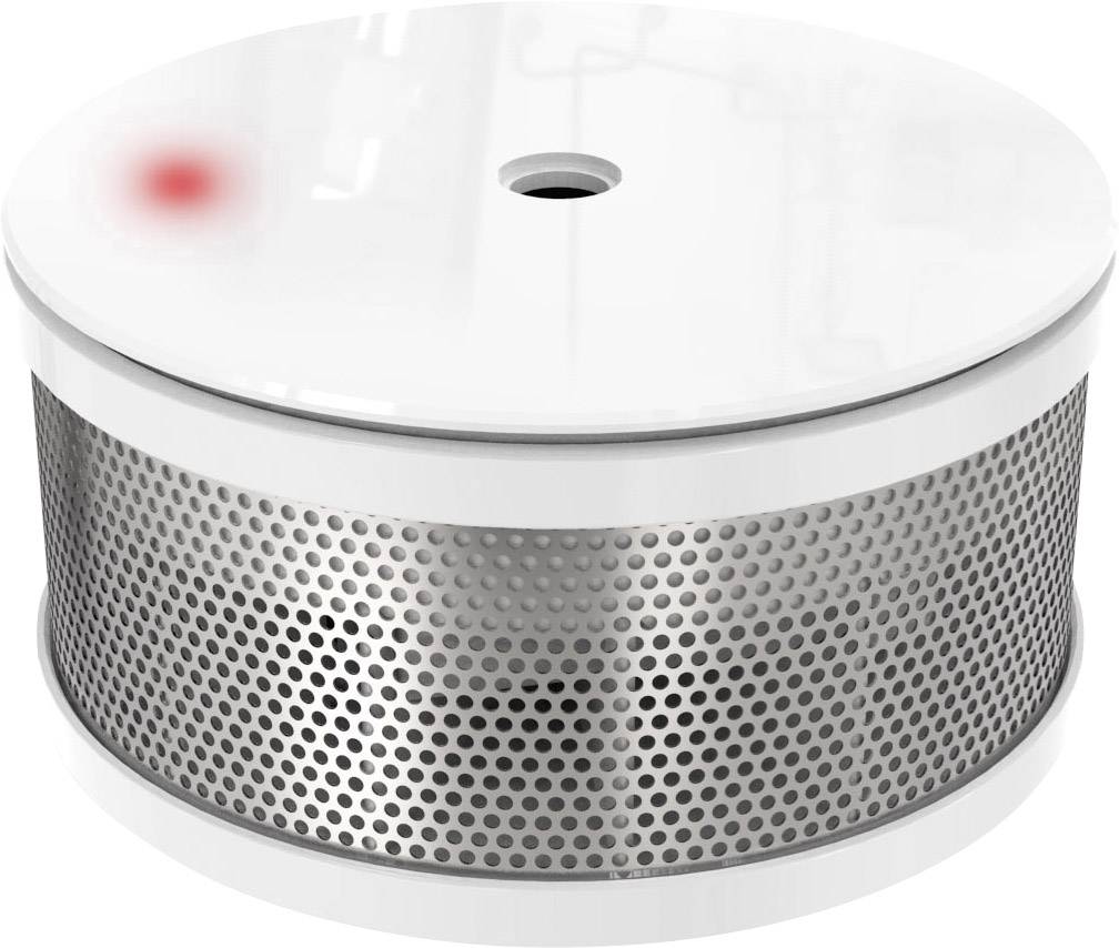 Détecteur de fumée rond avec boîtier blanc et grille argentée. Un voyant rouge s'allume en haut à gauche, indiquant l'état de fonctionnement.