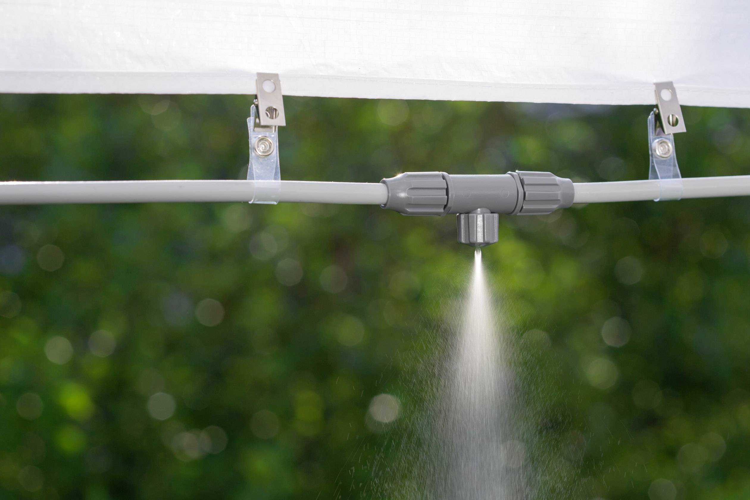 Un système d'irrigation pulvérise un fin brouillard à partir d'un gicleur.