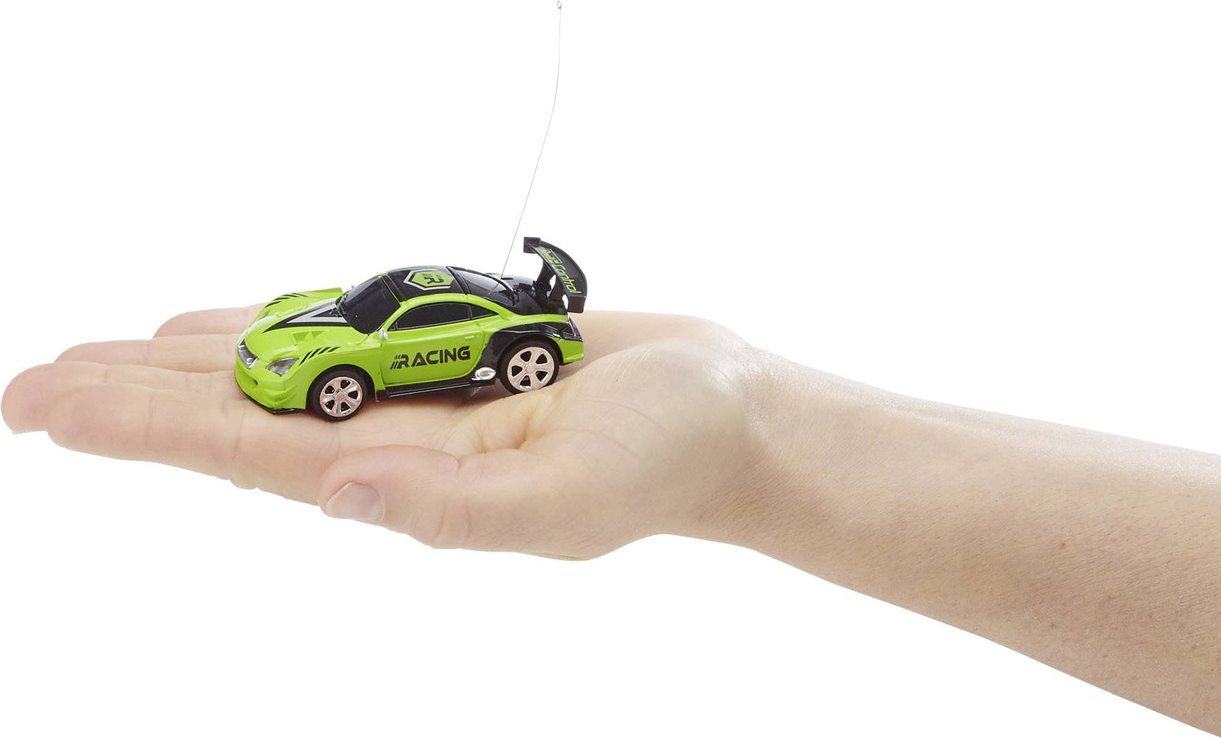 Une main tient une petite voiture télécommandée verte portant l'inscription 'Racing' sur le côté.