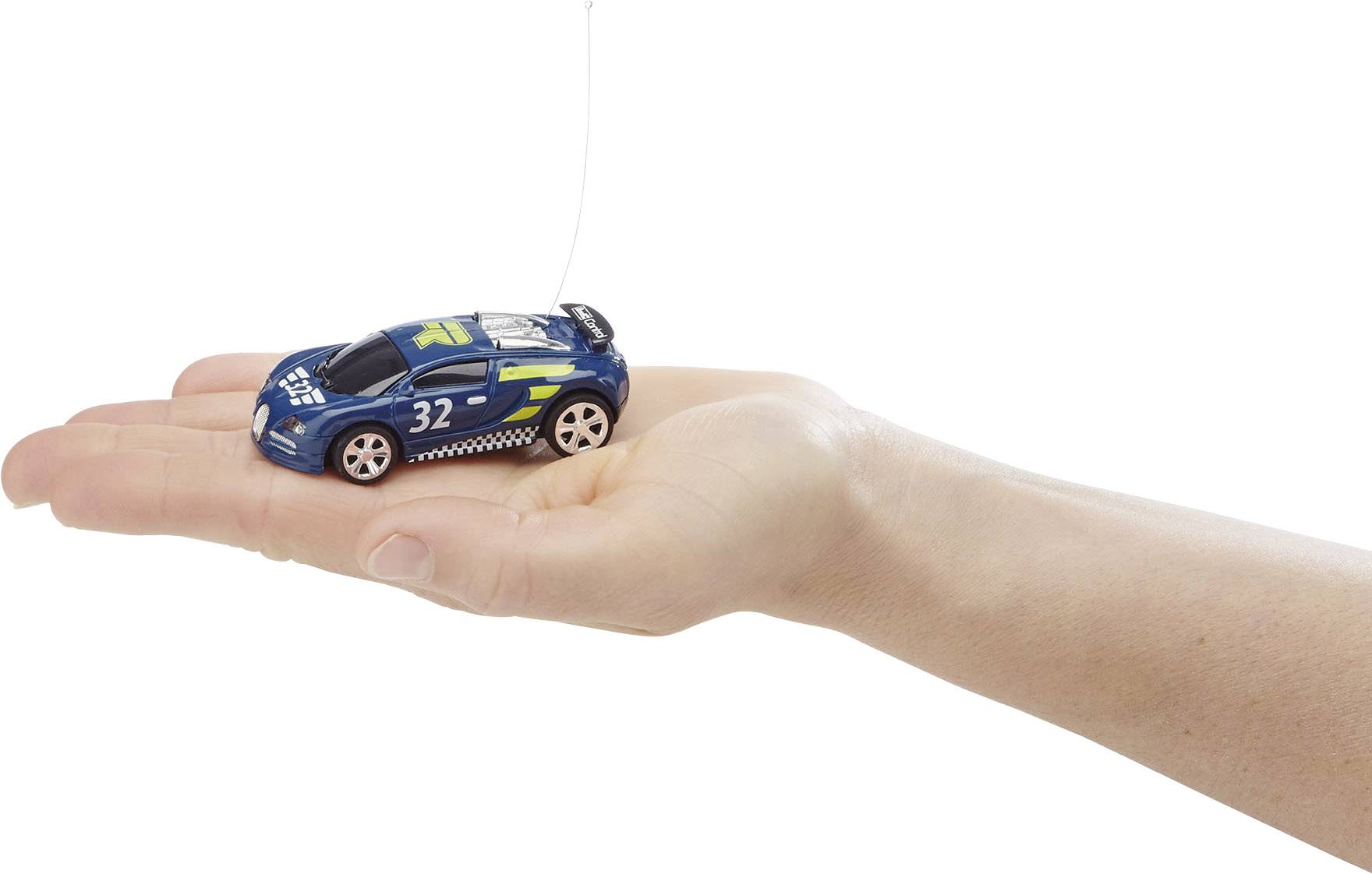Une main tient une petite voiture miniature, un modèle d'une voiture de course bleue portant le numéro '32', sur un fond blanc.