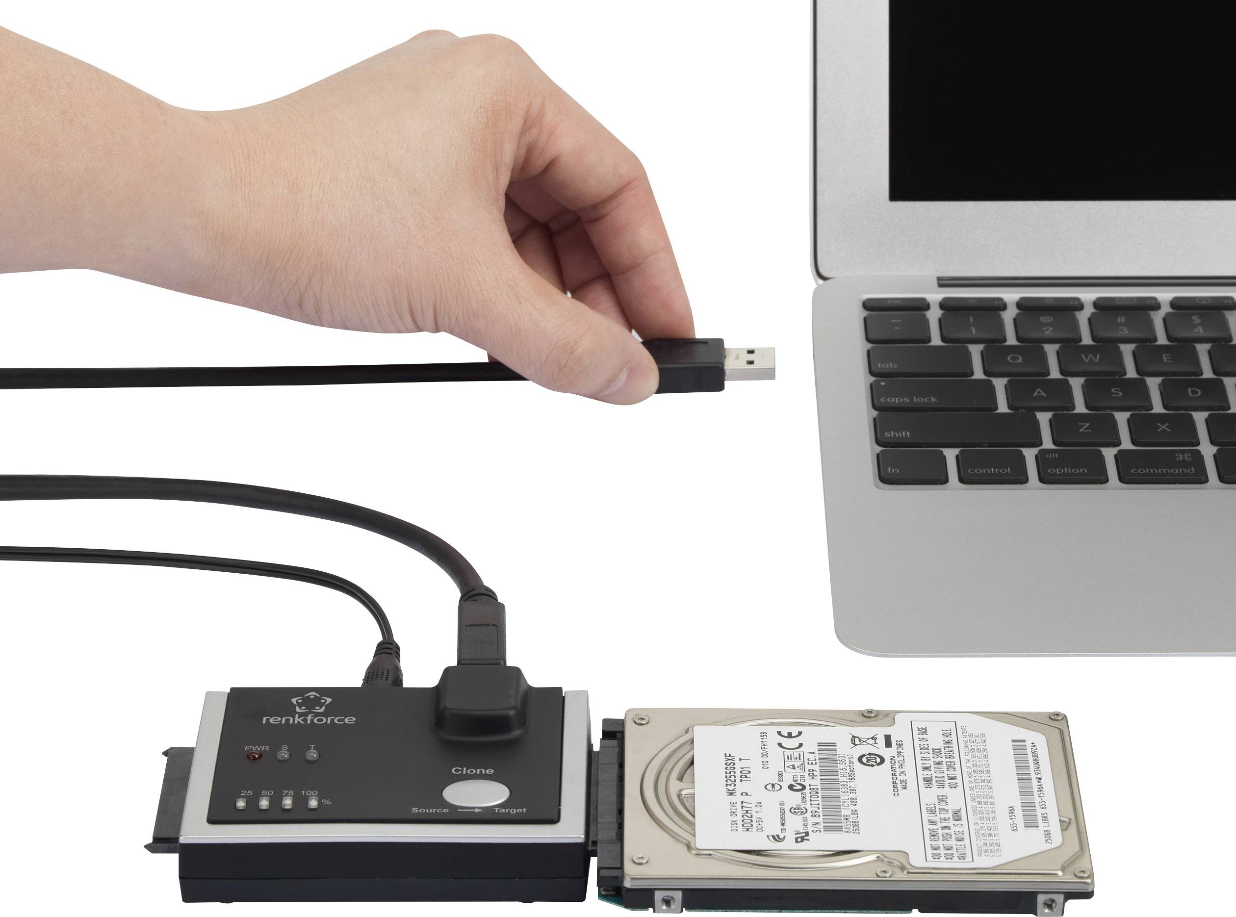 Une main connecte un câble USB d'un périphérique de copie de données à un ordinateur portable. Un disque dur est branché sur l'appareil de copie.
