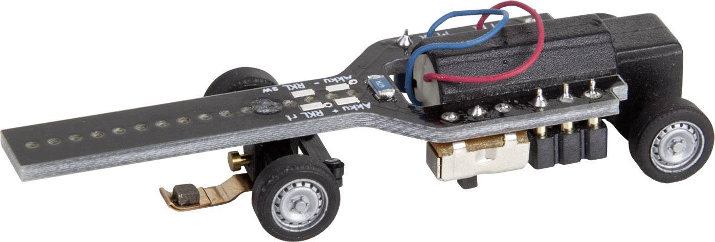 Un petit capteur ou interrupteur électronique noir avec des roues, des fils et des pièces métalliques, probablement destiné à la maquette ou à l'expérimentation technique.