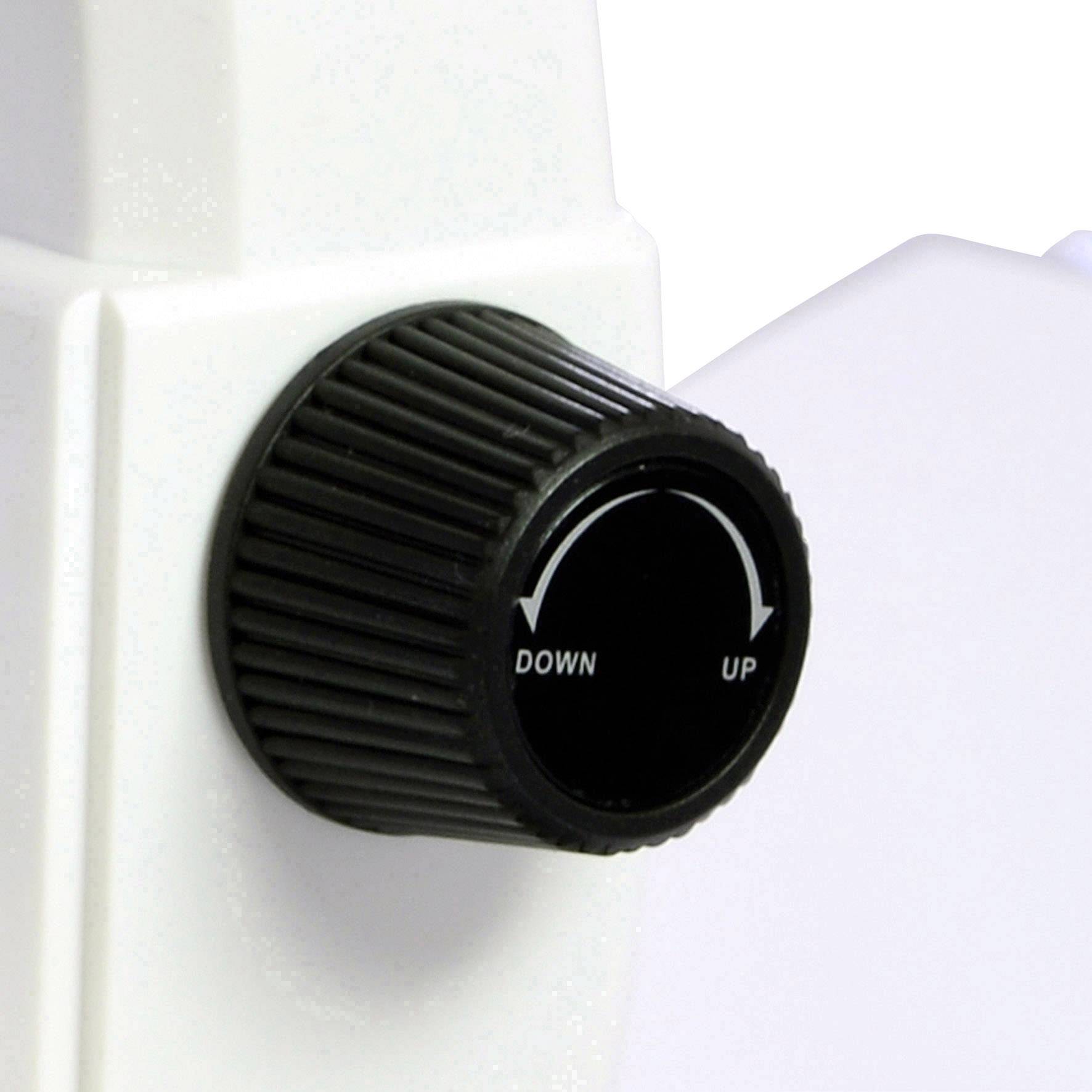 Un bouton noir rotatif portant les inscriptions 'UP' et 'DOWN' sur un appareil blanc utilisé pour le réglage précis d'une lentille optique.