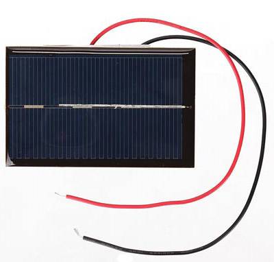 Panneau solaire avec deux câbles, rouge et noir, pour la conversion d'énergie en électricité.