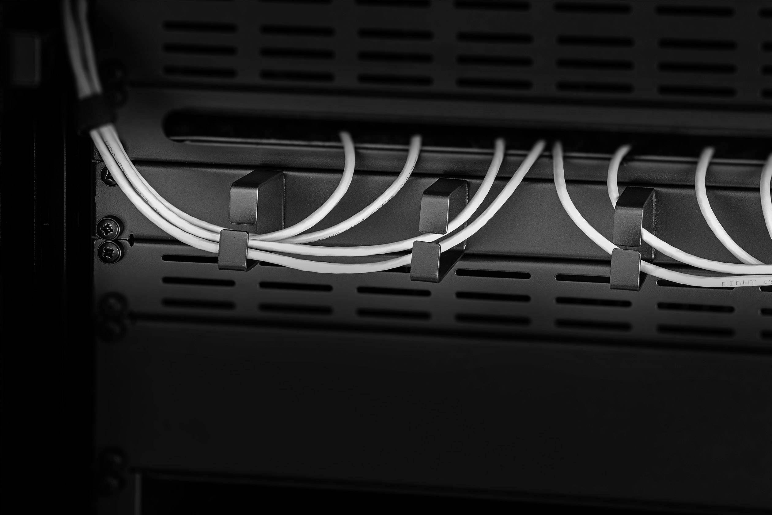 Serveur réseau, en noir et blanc. Plusieurs câbles Ethernet sont connectés à un rack. Centre de données ou infrastructure informatique.