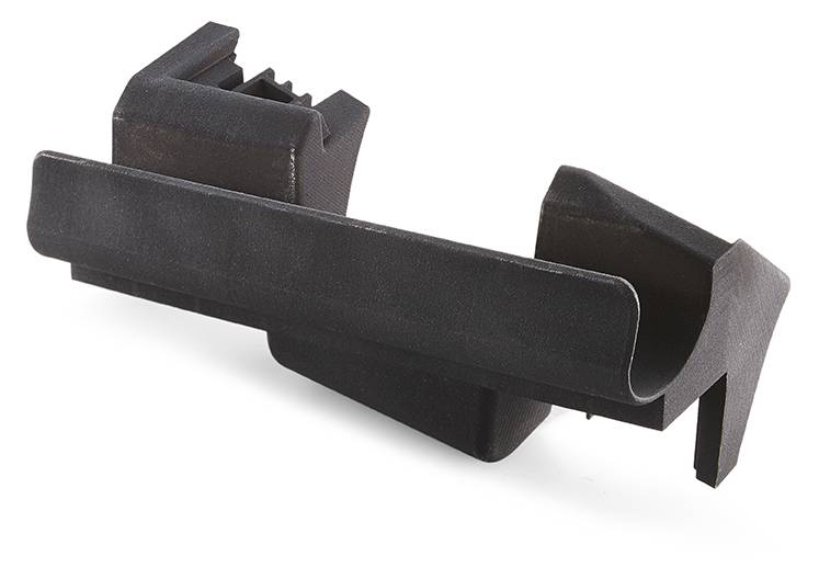 Pièce en plastique teintée en noir avec des découpes rectangulaires et des bords plats, probablement un boîtier pour des applications techniques.