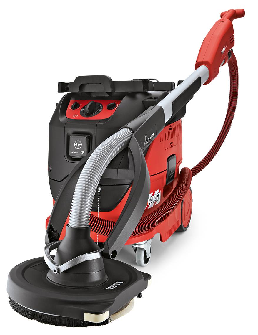 Un aspirateur industriel rouge avec rallonge de tuyau et embout de nettoyage, adapté pour le nettoyage professionnel de surfaces.