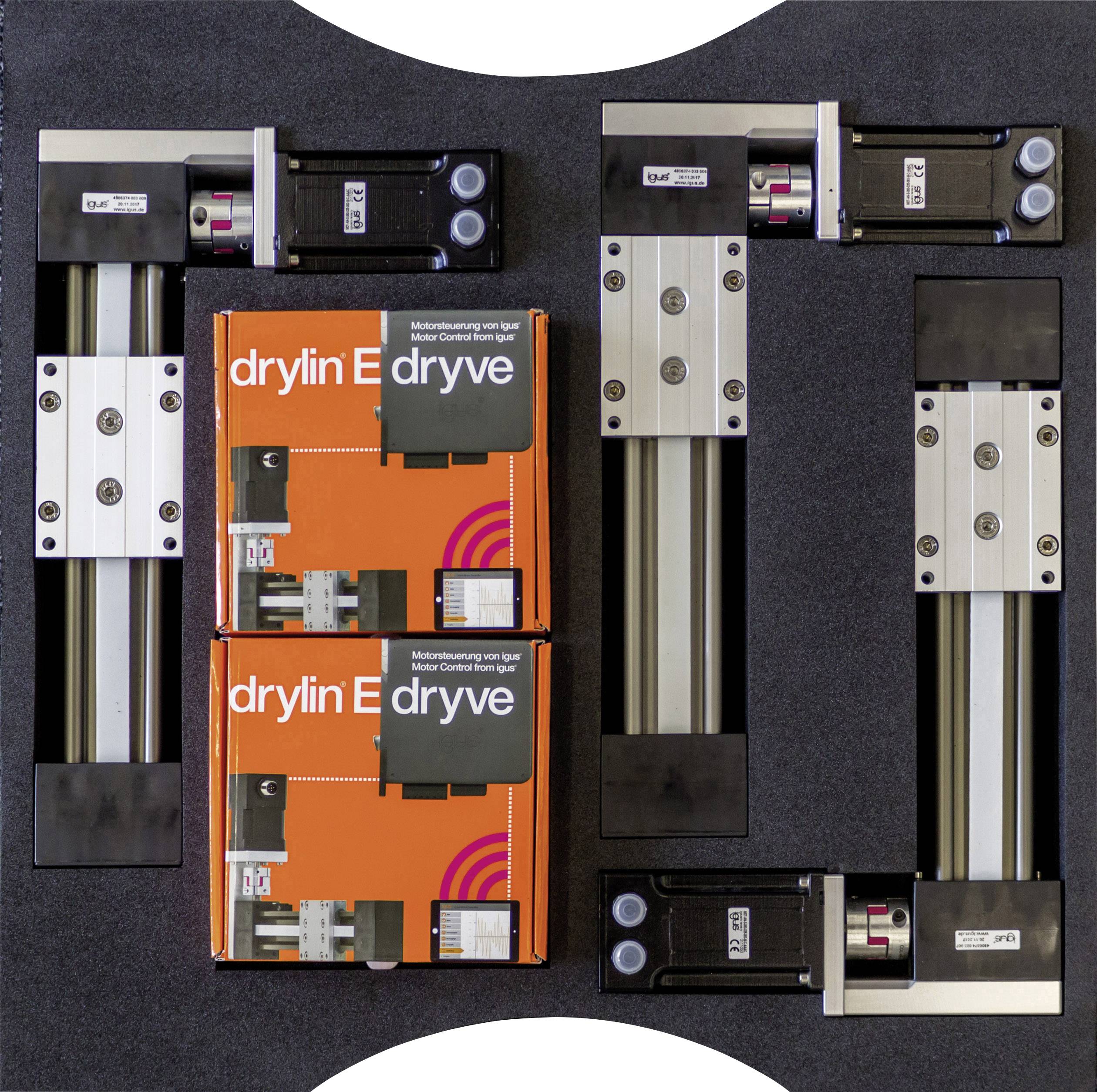 Commandes de moteurs fixées sur des plaques métalliques, avec deux boîtes orange 'drylin E' au centre. La disposition forme les lettres 'IG'.