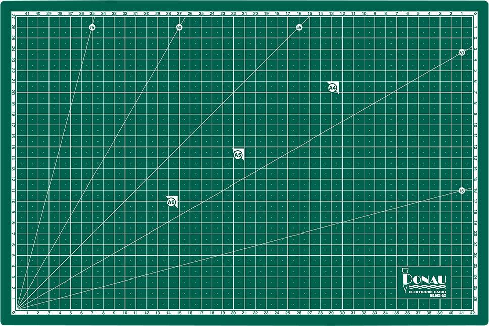 Tapis de coupe vert avec des lignes de quadrillage blanches et des échelles de mesure sur les bords.