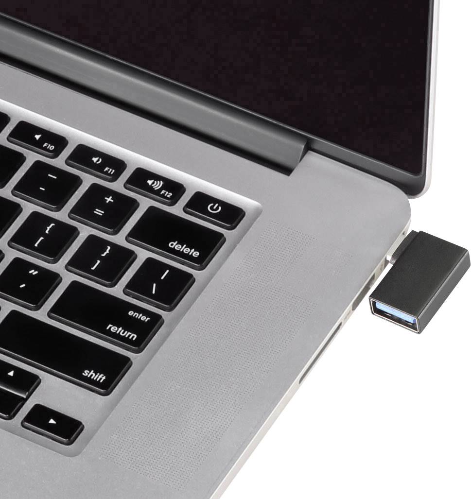 Un ordinateur portable avec une clé USB branchée sur le côté droit. L'écran est partiellement visible.