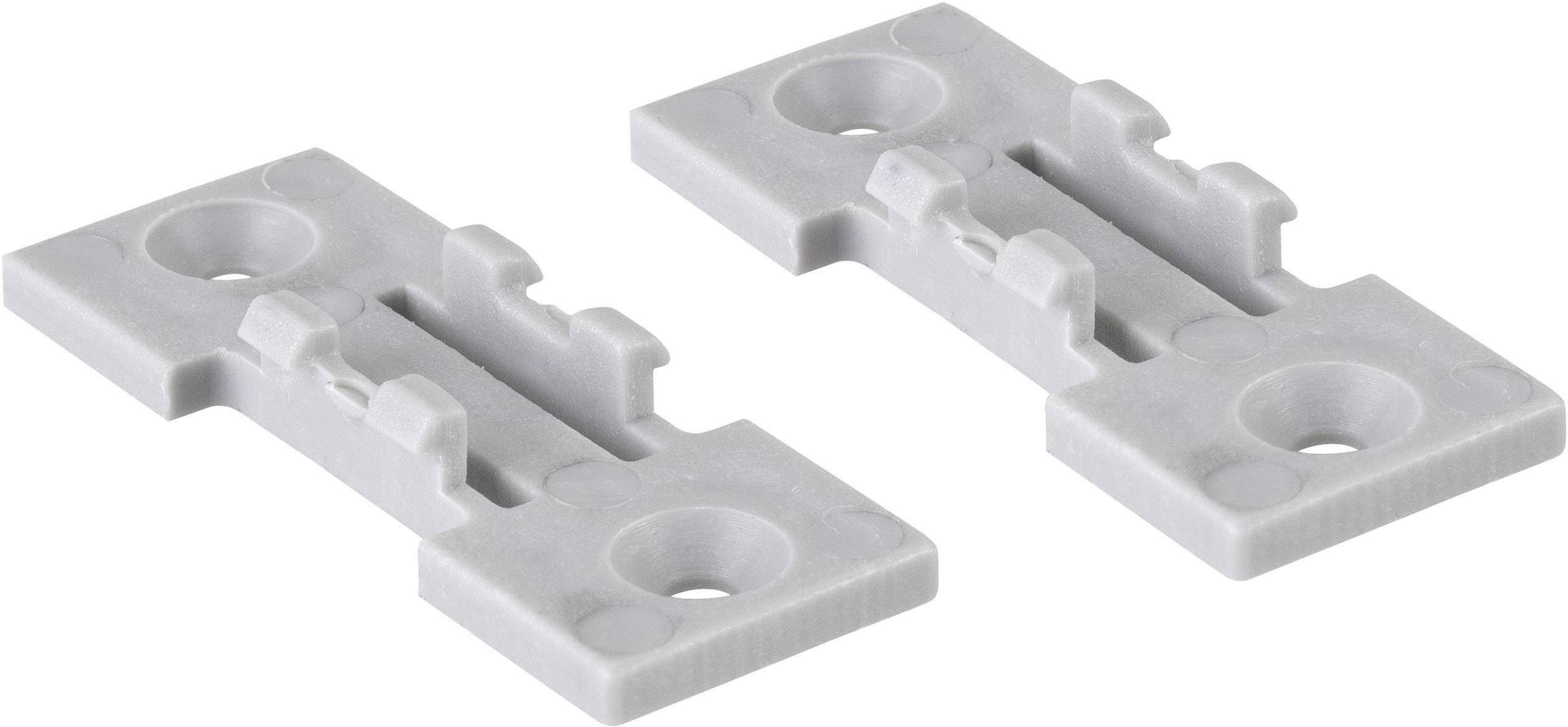 Deux attaches de fixation en plastique gris pour montage de meubles, placées côte à côte, chacune avec trois trous ronds.