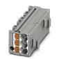 Un connecteur électrique rectangulaire gris avec plusieurs points de connexion, quatre inserts de broches de couleur orange sont visibles.