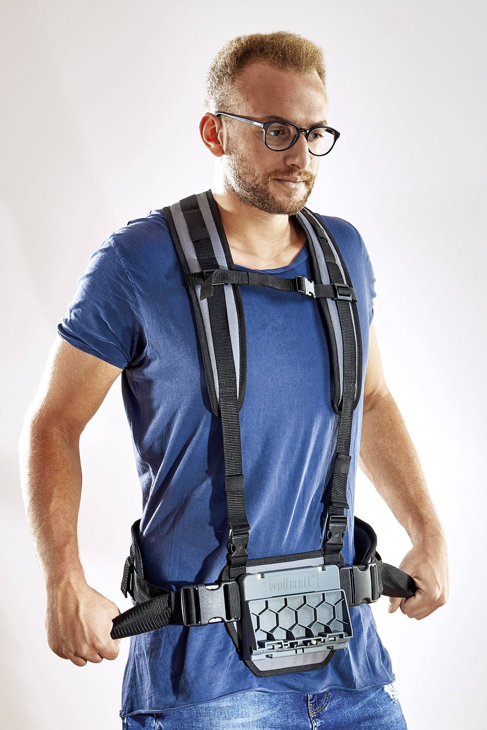 Un homme portant des lunettes est équipé d'un système de transport moderne avec des sangles d'épaule et une ceinture rembourrée.