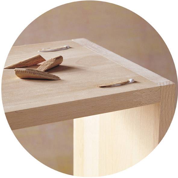 Gros plan d'une cheville en bois et de copeaux de bois sur une table.