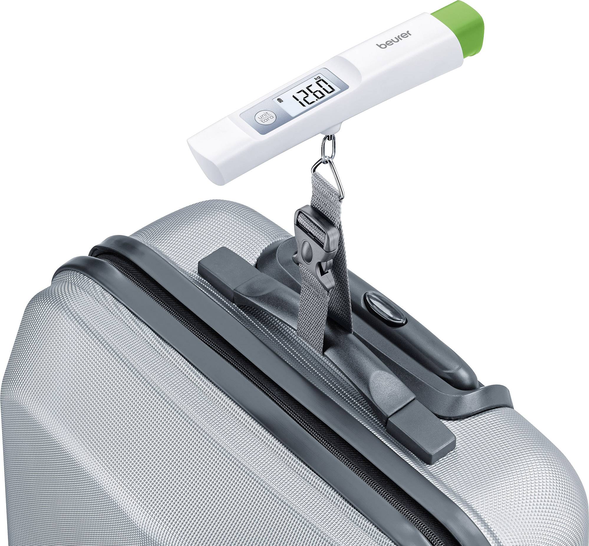 Une valise d'argent est pesée par une balance numérique de bagages de cabine avec un résultat de '12,6 kg'.