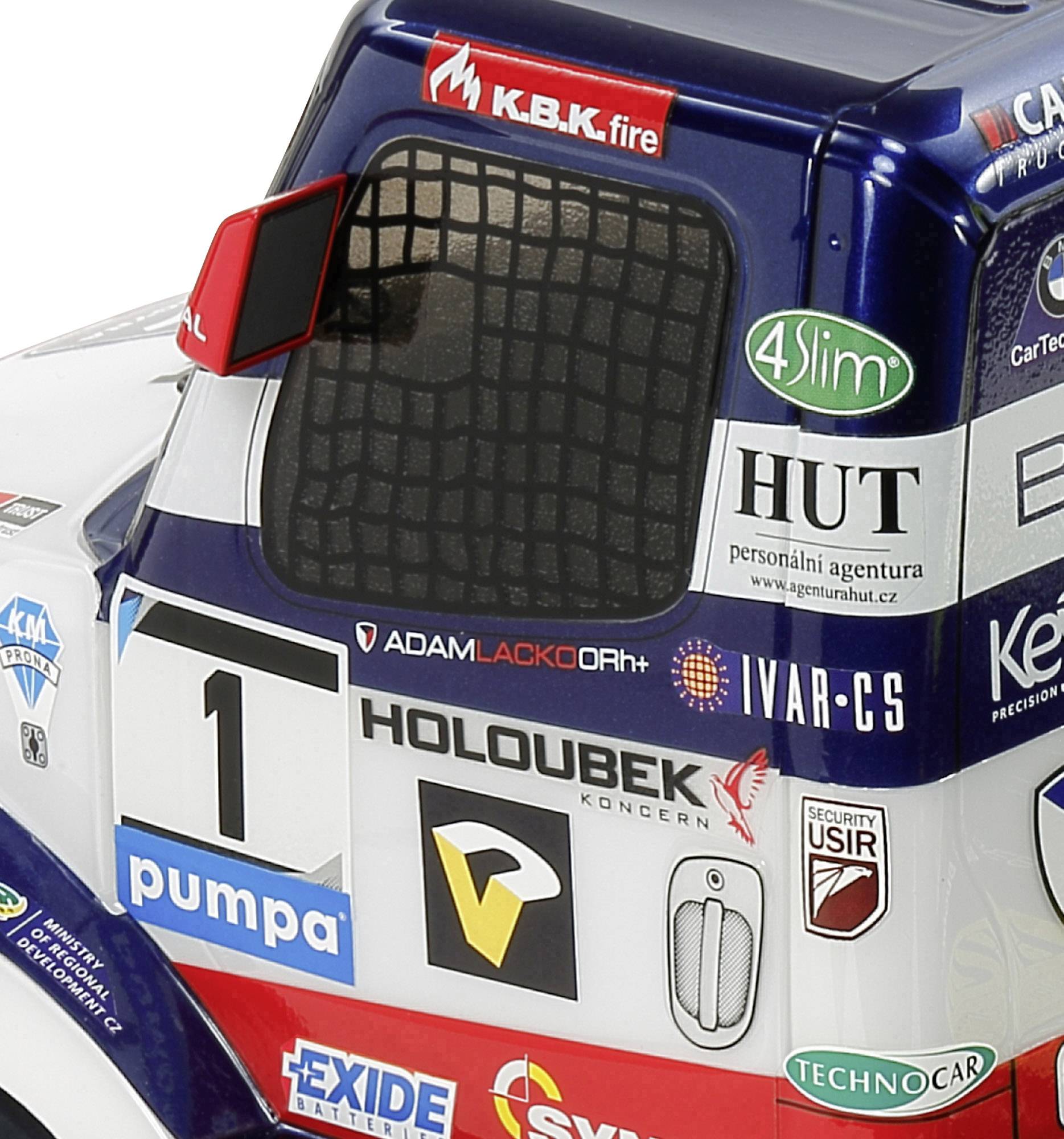 Gros plan sur un camion de course bleu portant le numéro 1, recouvert d'autocollants de sponsors, dont 'Holoubek' et 'Hut'.